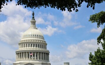 Lawmakers Introduce Bipartisan Full House Act to Restore Full Gambling Loss Deduction The U.S. Capitol building in Washington, D.C., seen beneath a blue sky with trees framing the dome.