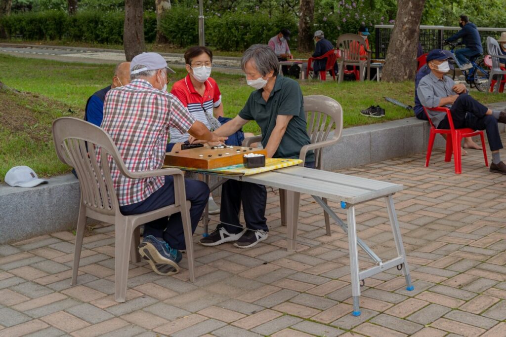 Elderly South Koreans play Go in a public park.