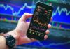 Many Americans Believe Prediction Markets are Reshaping Culture, Survey Shows Smartphone displaying market charts, reflecting growing interest in prediction markets and online betting culture