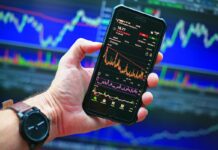 Many Americans Believe Prediction Markets are Reshaping Culture, Survey Shows Smartphone displaying market charts, reflecting growing interest in prediction markets and online betting culture