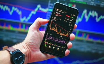 Many Americans Believe Prediction Markets are Reshaping Culture, Survey Shows Smartphone displaying market charts, reflecting growing interest in prediction markets and online betting culture