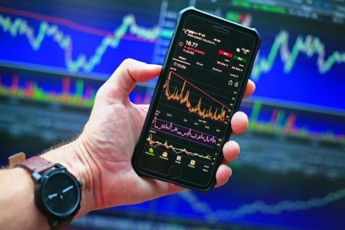 Many Americans Believe Prediction Markets are Reshaping Culture, Survey Shows Smartphone displaying market charts, reflecting growing interest in prediction markets and online betting culture
