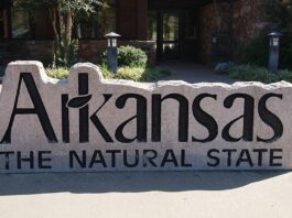 FanDuel, DraftKings File Applications to Enter Arkansas Sports Betting Market Stone sign reading “Arkansas The Natural State” outside a public building
