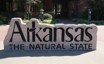 FanDuel, DraftKings File Applications to Enter Arkansas Sports Betting Market Stone sign reading “Arkansas The Natural State” outside a public building