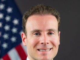 Selig Asserts CFTC Dominance as States Target Prediction Markets Portrait of CFTC Chariman Michael Selig in a suit standing in front of an American flag.