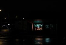 A neon sign in a window that says Money to Loan.