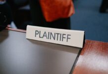 A plaintiff sign sits on a desk.