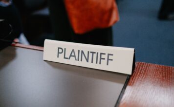 A plaintiff sign sits on a desk.