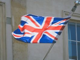 UK Government To Ban Unlicensed Gambling Companies From Sponsoring Sports Teams The UK flag waving on a flagpole.