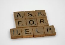 Wooden letter tiles spelling “ask for help” on a white background