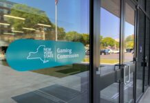 Entrance to the New York State Gaming Commission building with the agency’s logo displayed on the glass door.