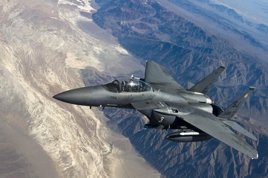 U.S. Air Force F-15E Strike Eagle flying over mountainous terrain