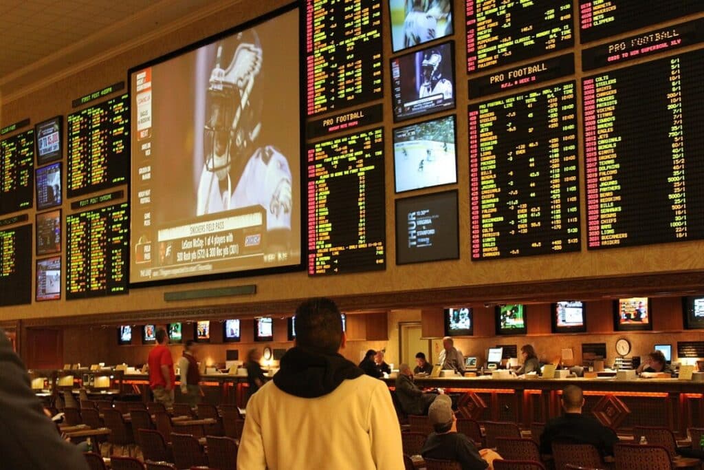 Sports bettors watch games and odds boards inside a Las Vegas sportsbook