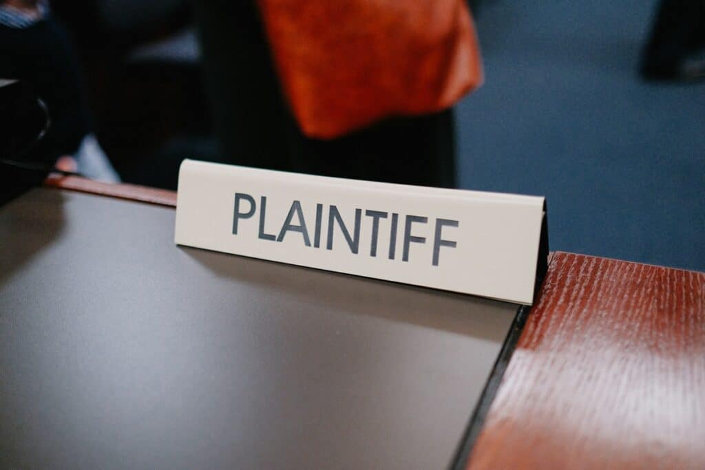 A plaintiff sign on a courtroom desk.