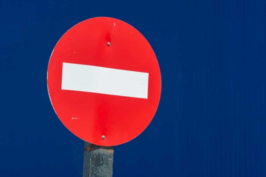 A circular red road sign with a horizontal white line across it.