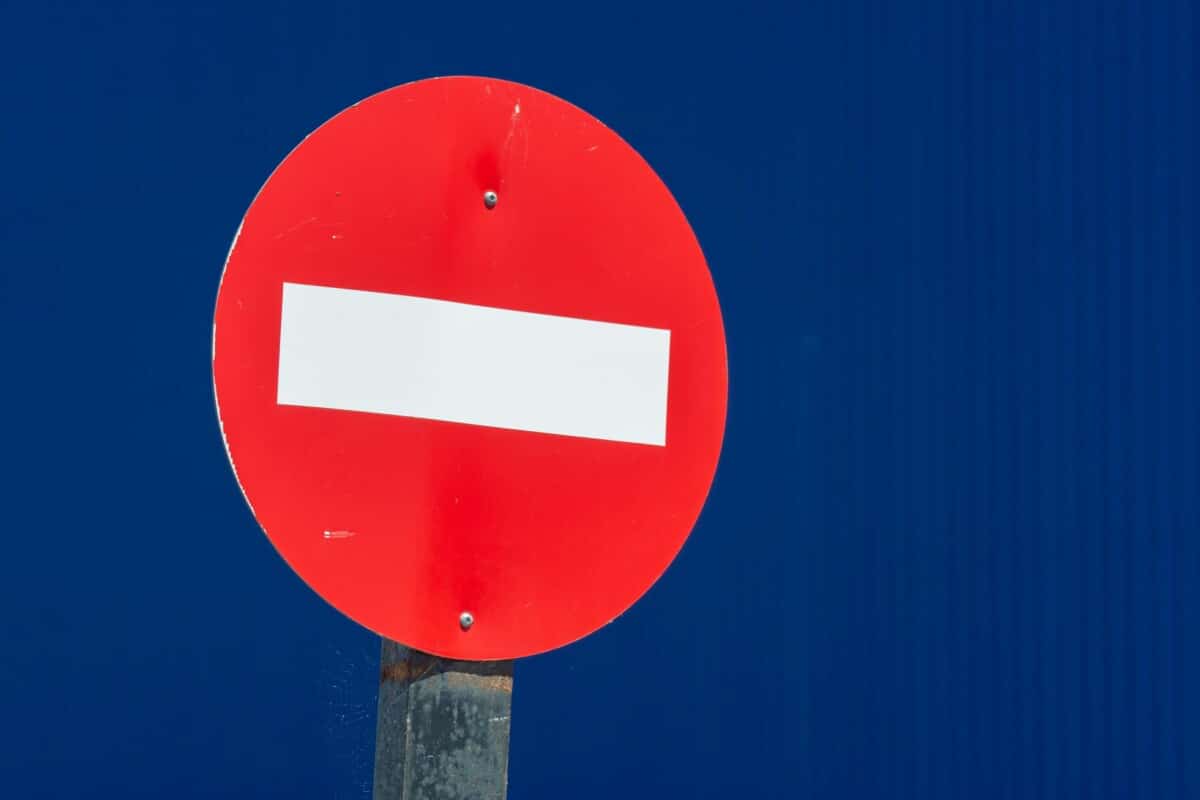A circular red road sign with a horizontal white line across it.