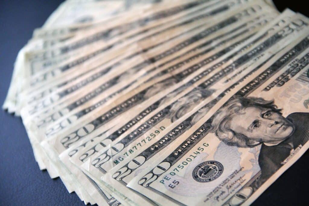 A spread of US $20 bills on a table.