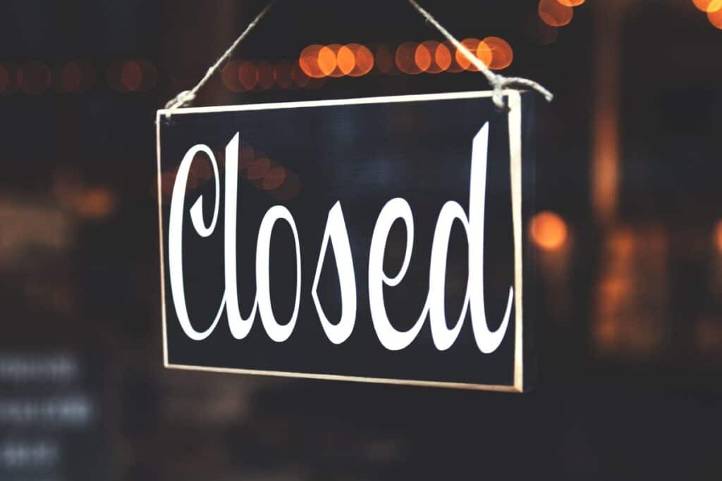 A black and white hanging Closed sign.